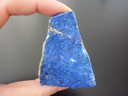 lapis lazuli minerál držený v prstech přední strana