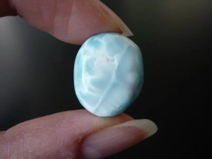 larimar minerál držený v prstech přední strana