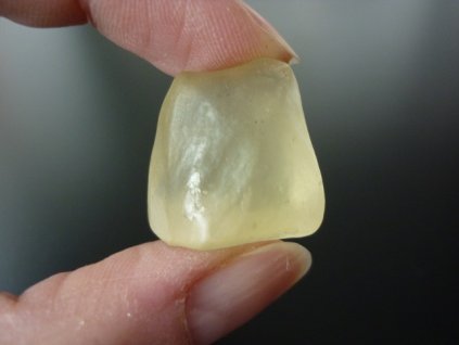 Libyjské sklo držené v prstech přední strana