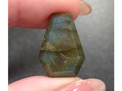 labradorit minerál držený v prstech