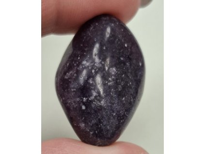 lepidolit minerál držený v prstech detail