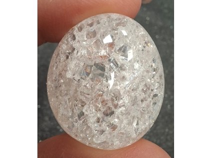 křišťál pukaný držený v prstech detail