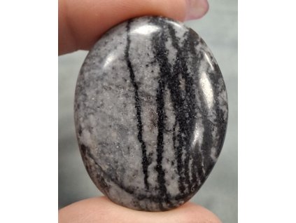 minerál jaspis zebra držený v prstech přední strana detail