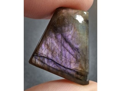 minerál labradorit držený v prstech detail