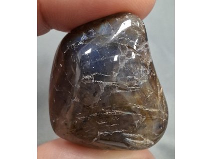 labradorit minerál držený v prstech detail přední strana