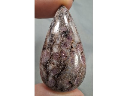 rubín v křemeni minerál držený v prstech detail