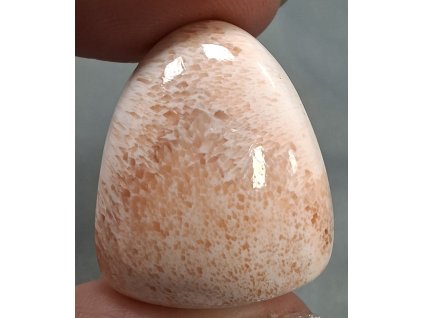 skolecit minerál držený v prstech detal