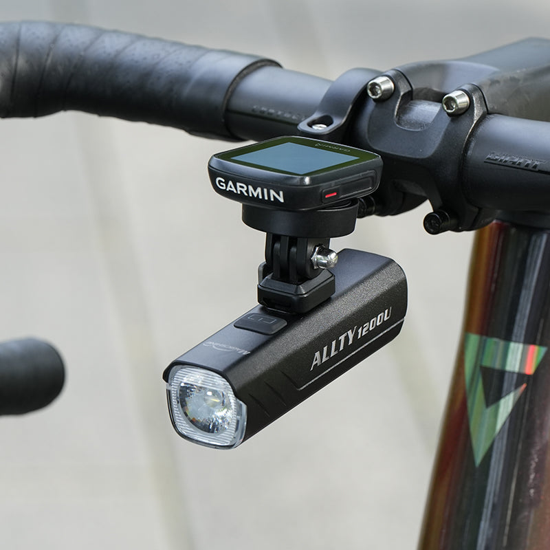 Magicshine ALLTY 1200U zavesený pod predsadeným držiakom s cyklopočítačom Garmin na riadidlách