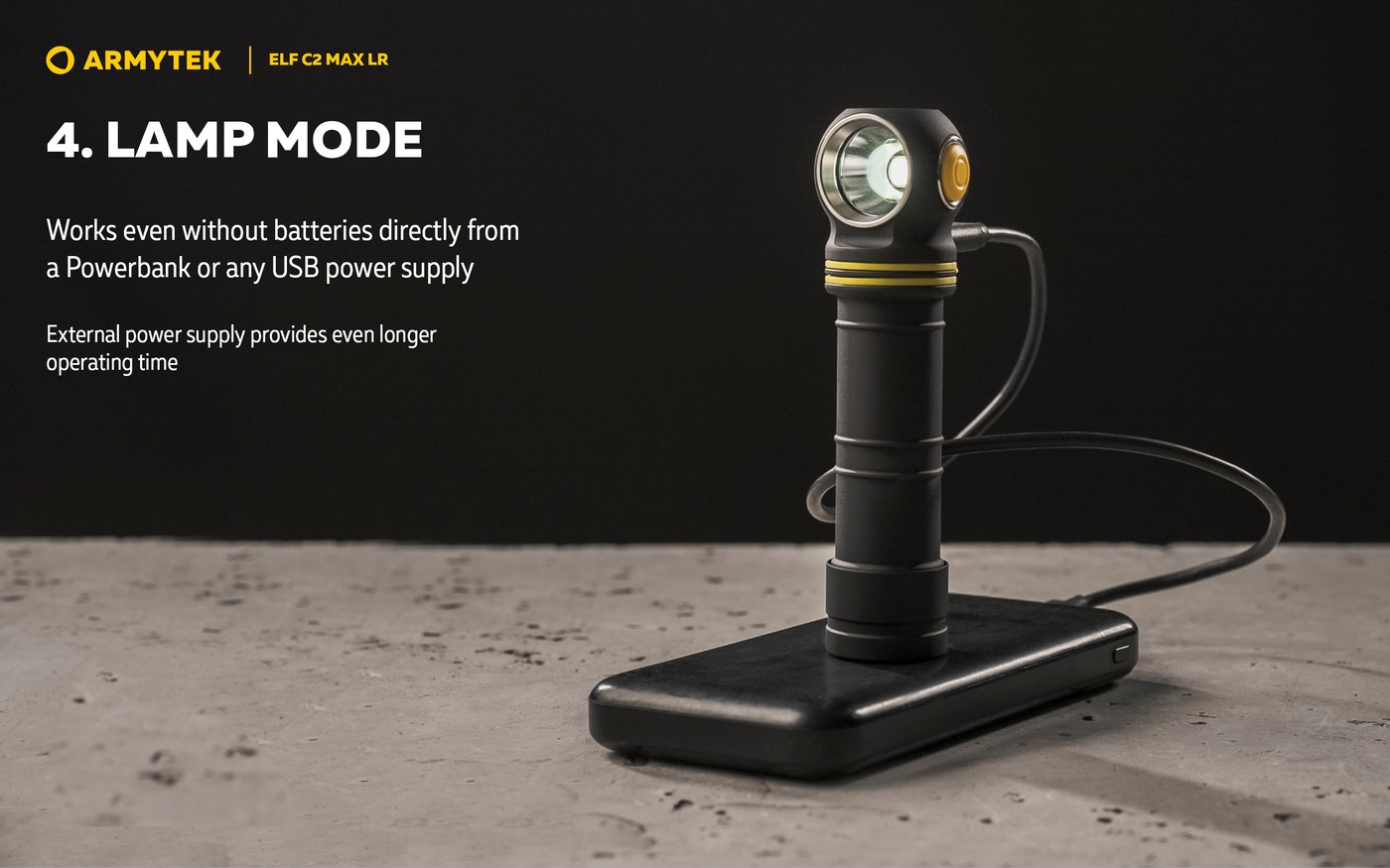 Čelovka Armytek Elf C2 Max LR stojí na powerbanke a svieti v režime lampy, kábel USB-C zapojený z boku hlavy