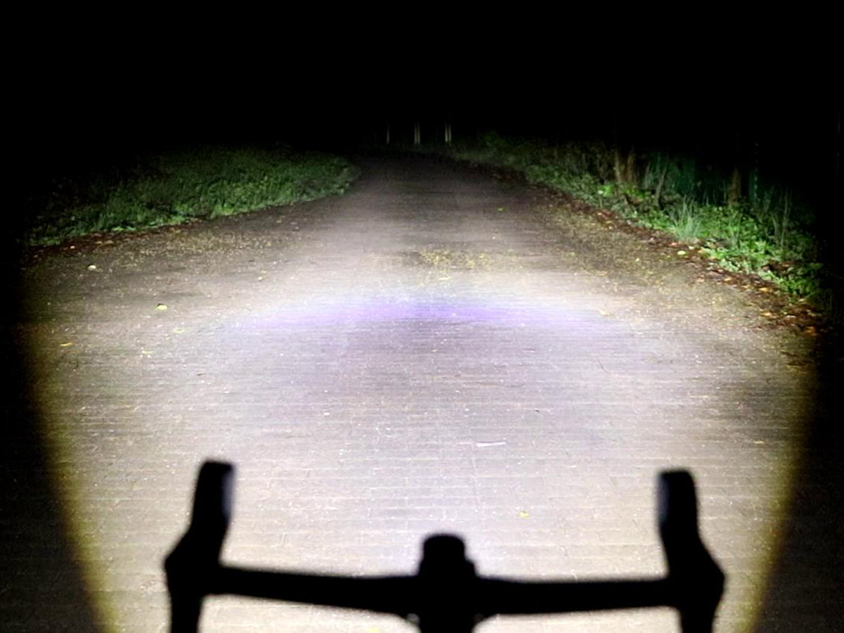 Nočný pohľad spoza riadidiel — Magicshine EVO 1100 osvetľuje cestu širokým lúčom s ostrou hornou hranicou