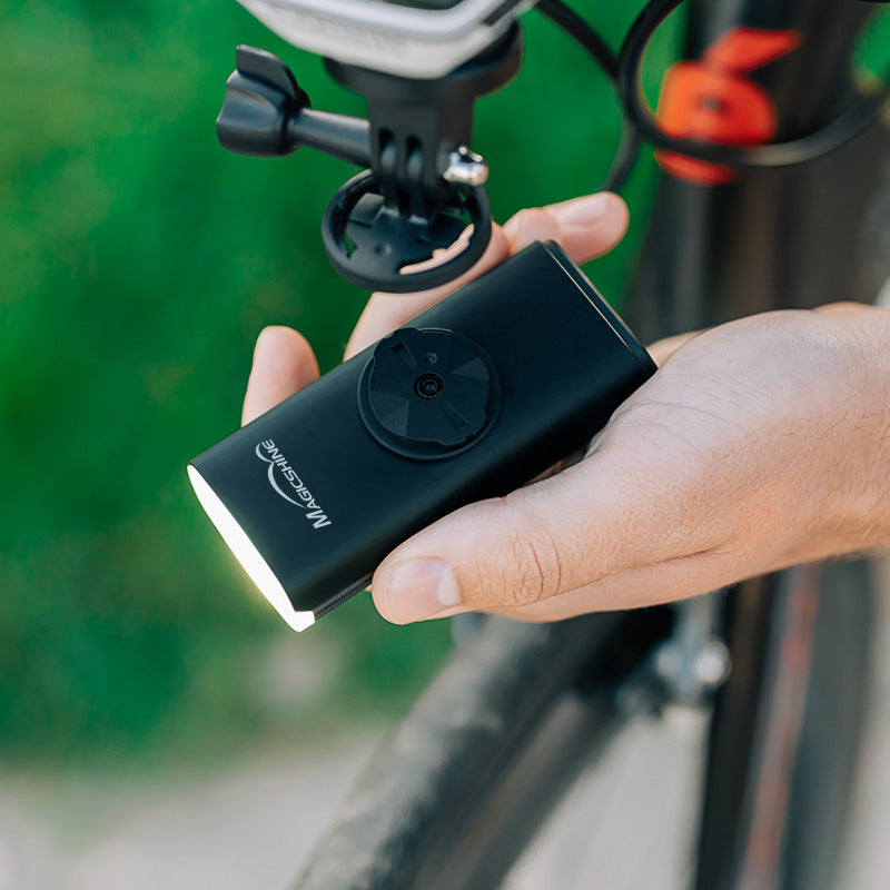 Ruka nasadzuje Magicshine EVO 1300 na štvrťotáčkový úchyt Garmin pod predsadeným držiakom