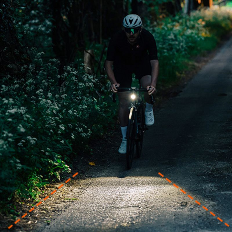 Cyklista na nočnej ceste, Magicshine EVO 1300 osvetľuje široký pás vozovky pred kolesom