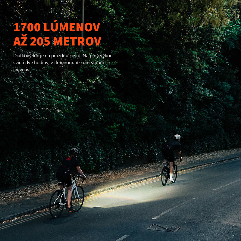 Cestní cyklisti za tmy, svetlo Magicshine EVO 1700 osvetľuje vozovku pred prvým z nich