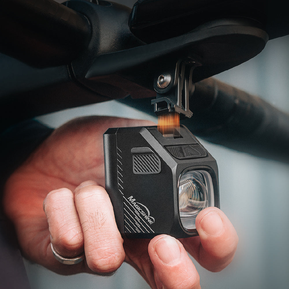 Magicshine EVO 1700 PRO sa oddeľuje od magnetického držiaka MagicLock, medzi dielmi oranžová žiara