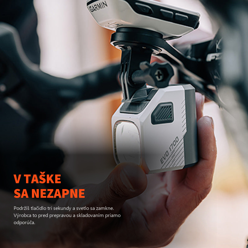 Rozsvietené svetlo Magicshine EVO 1700 v ruke pod cyklopočítačom Garmin, tlačidlo na tele slúži aj na zamknutie
