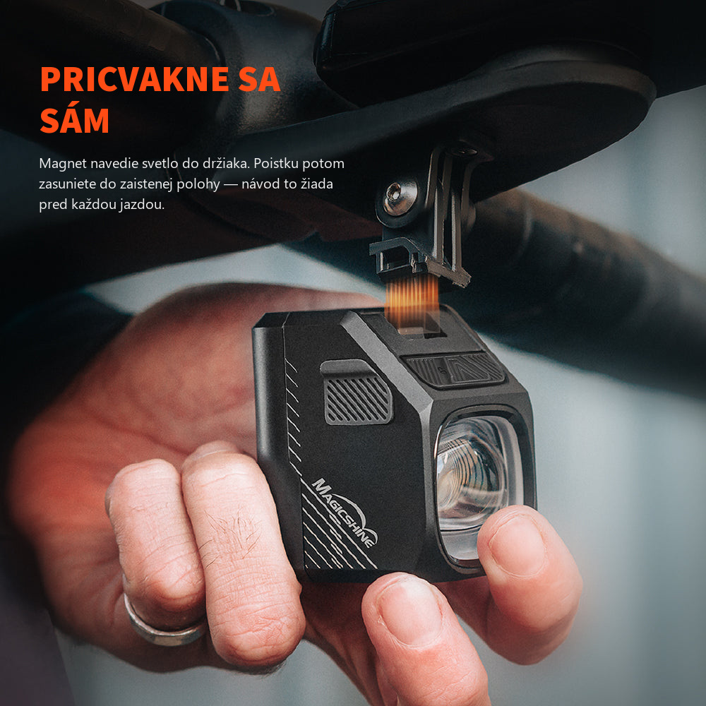 Ruka prikladá Magicshine EVO 1700 PRO k držiaku pod riadidlami — magnetické uchytenie MagicLock