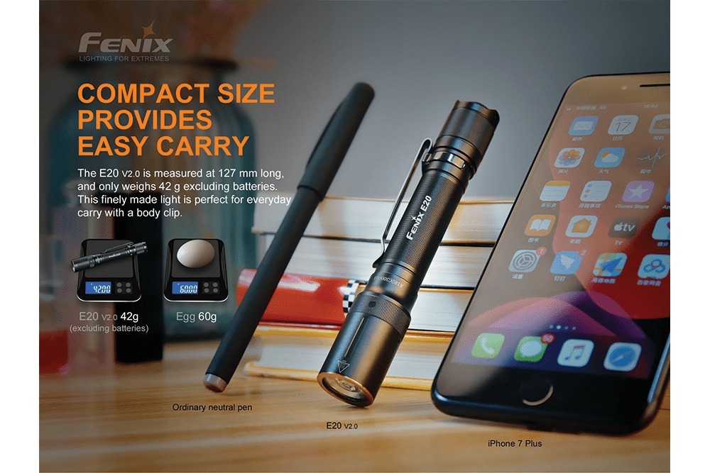Fenix E20 V2.0 dlhá 127 mm a ľahká 42 g bez batérií vedľa pera a mobilu, na váhe ľahšia než vajce