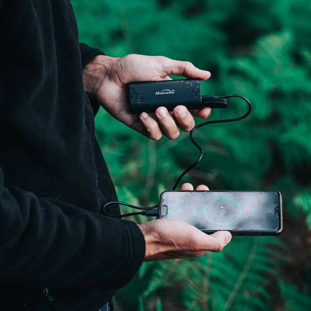 Akumulátor Magicshine MJ-6112 zo sady MJ-900S dobíja v teréne mobilný telefón — funkcia powerbanky cez Micro-USB