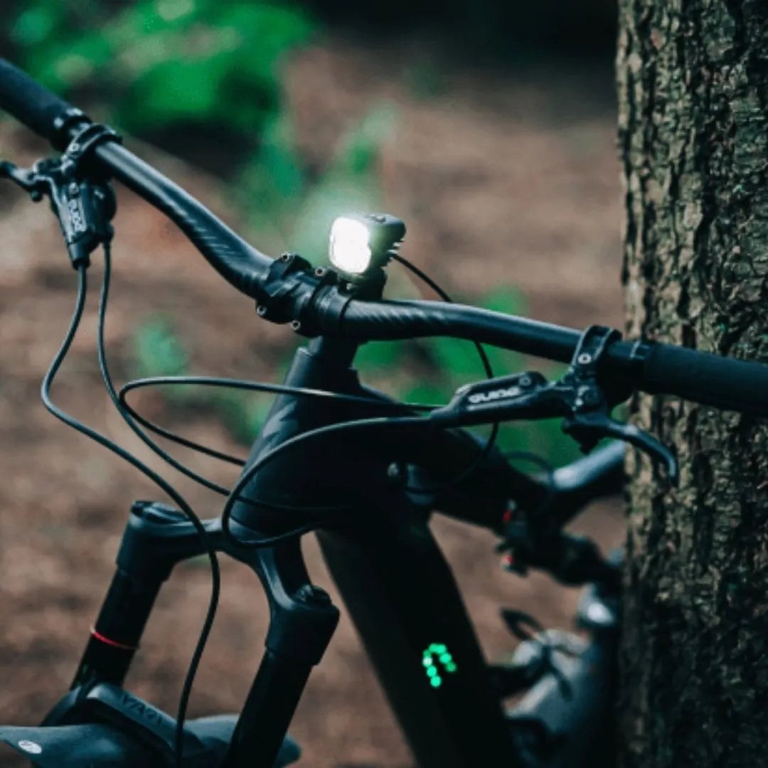 Magicshine MJ-900S svieti z riadidiel horského bicykla v lese, kábel k batérii vedie pozdĺž rámu