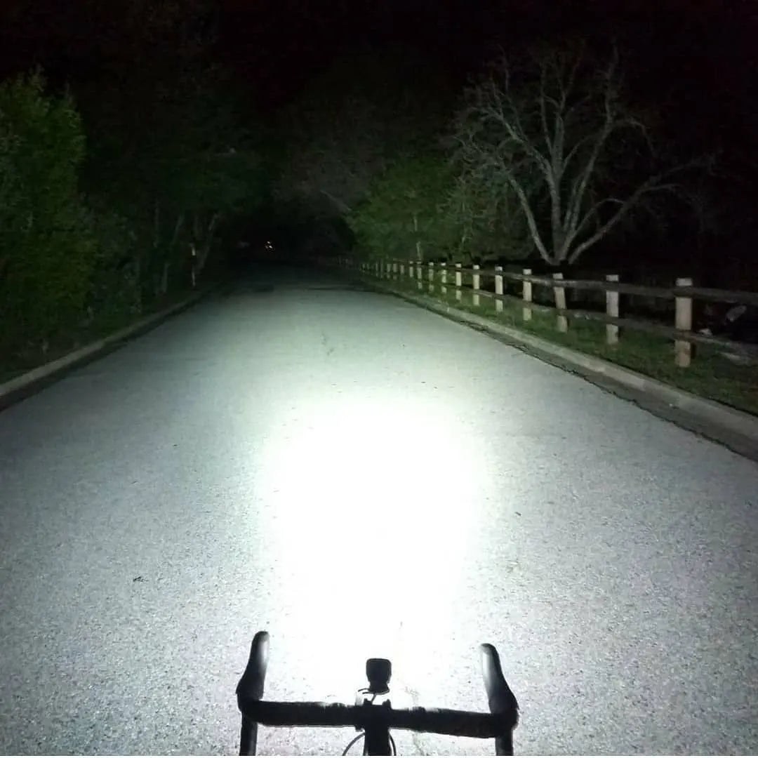 Nočná cesta osvetlená svetlom Magicshine MJ-900S &mdash; svetelný koberec pred cestným bicyklom siaha desiatky metrov dopredu