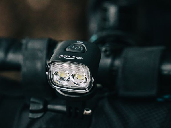 Detail Magicshine MJ-902S na riadidlách — mriežka denného svietenia nad dvojicou šošoviek