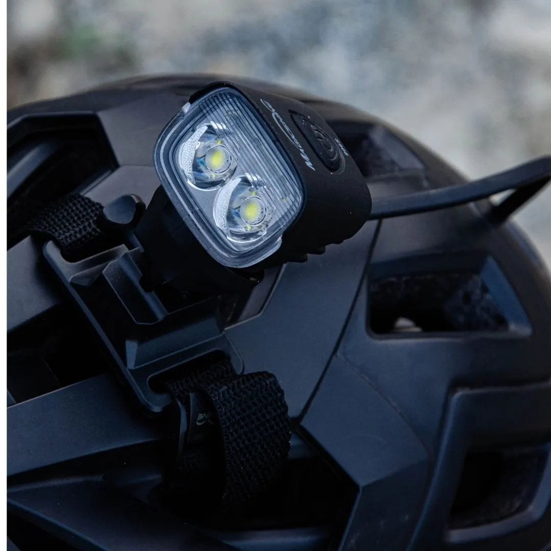 Magicshine MJ-906S nasadené na čiernej MTB prilbe, v detaile dve hlavné LED a chladiace rebrá