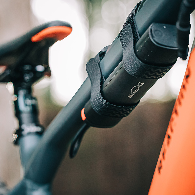 Akumulátor Magicshine MJ-6116C pripevnený suchými zipsami na hornej rámovej rúrke horského bicykla