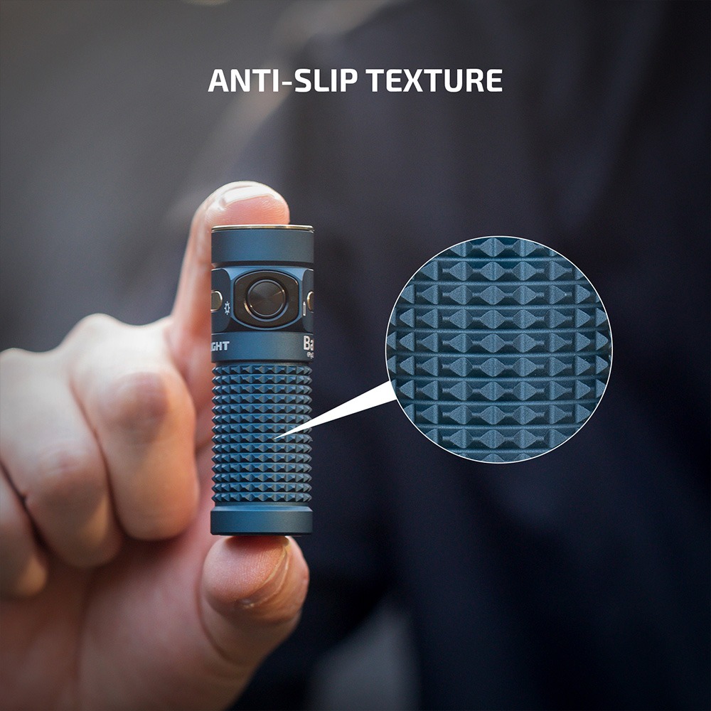 Olight Baton 4 protišmyková pyramídová textúra tela v detaile pod lupou, svietidlo držané medzi prstami