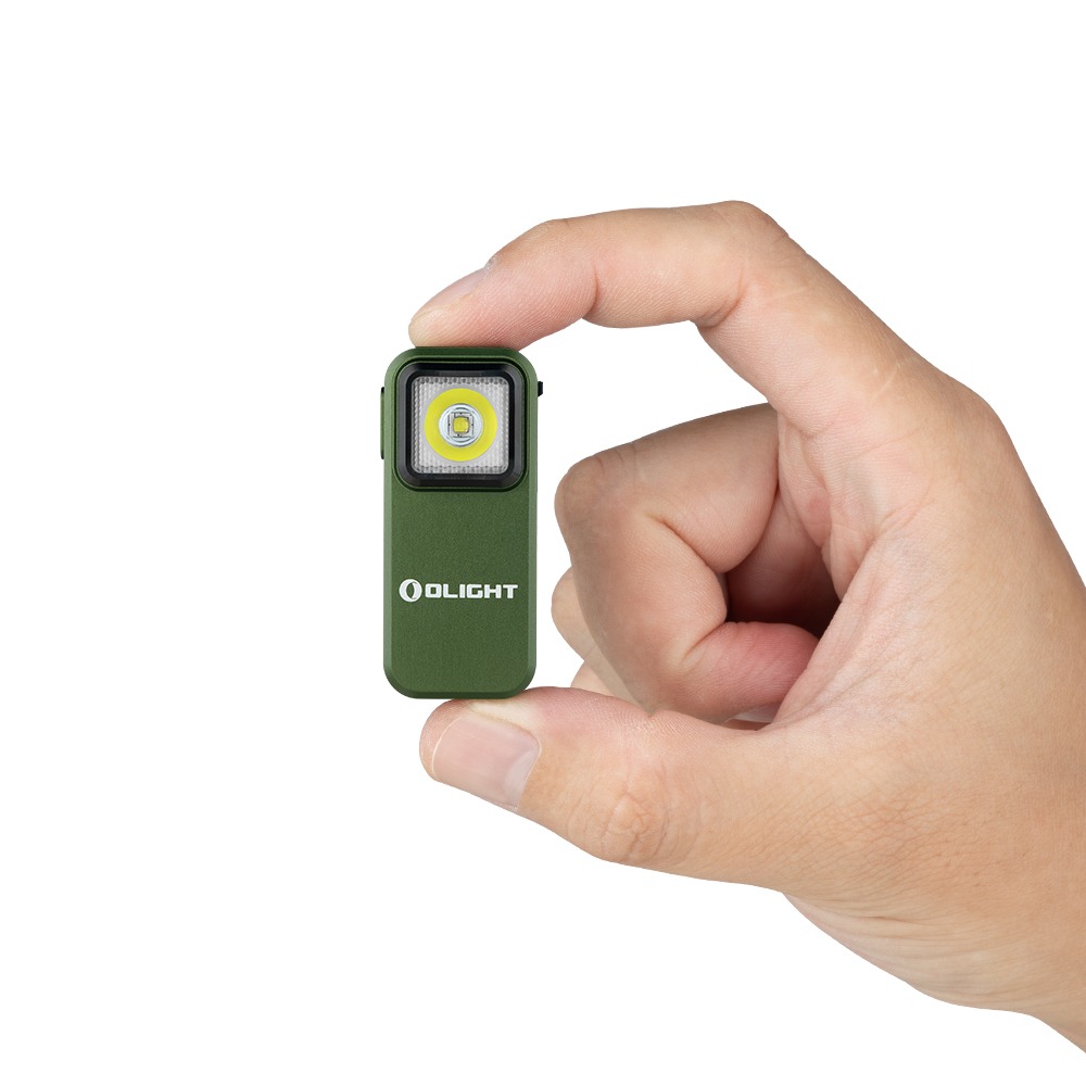 Olight Oclip Green medzi palcom a ukazovákom ukazuje veľkosť zeleného tela s čiernym lemom a LED