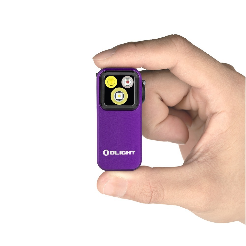 Olight Oclip Pro Purple medzi prstami ukazuje veľkosť plochého tela s tmavým lemom a tromi LED
