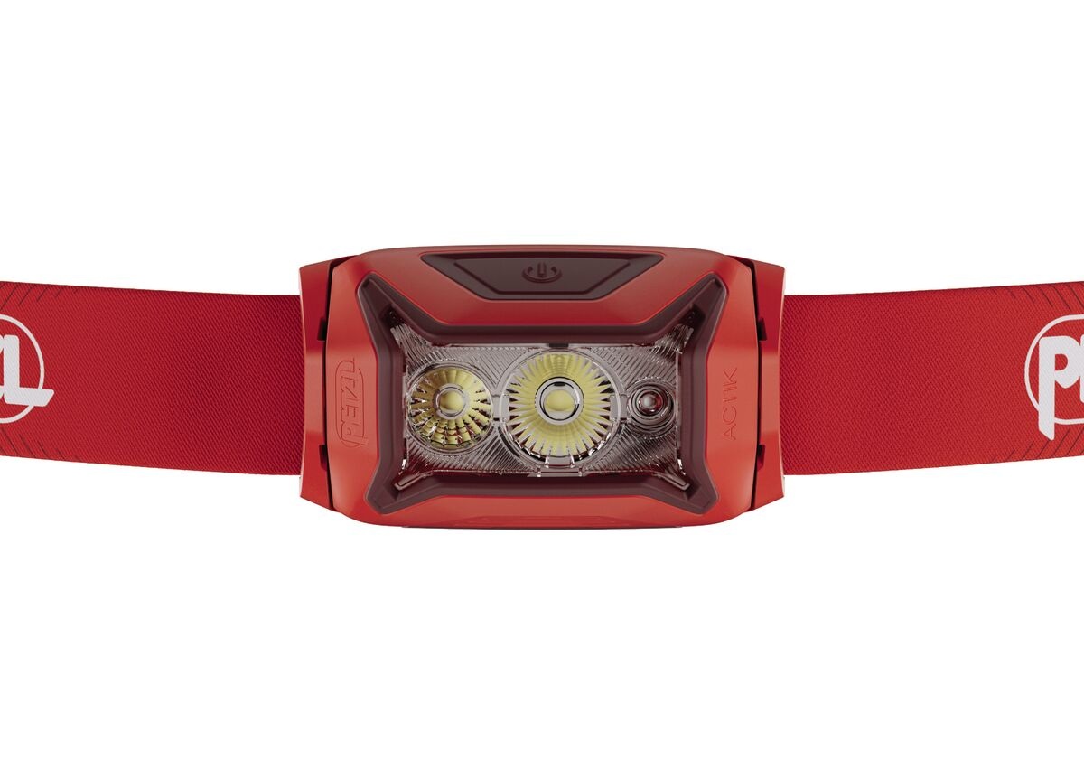 Petzl ACTIK zblízka spredu — v optike dve biele LED s odlišnými reflektormi vedľa seba a vpravo od nich malá červená LED