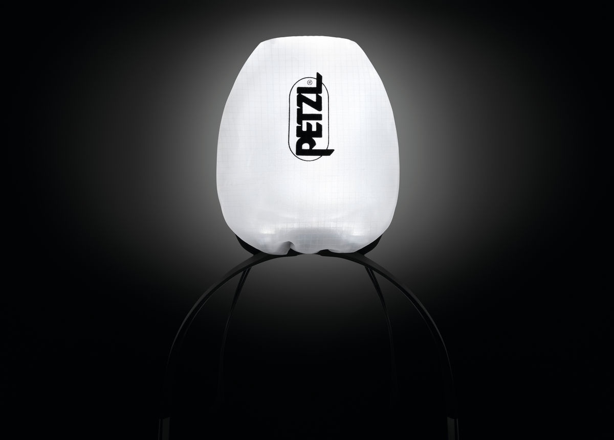 Petzl IKO CORE ako lampáš — rozsvietená čelovka v bielom púzdre rozptyľuje svetlo do celého priestoru v tme