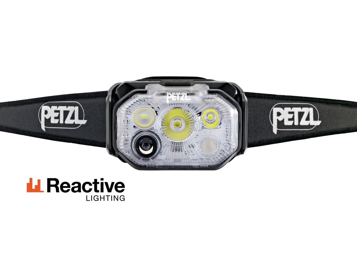 Petzl SWIFT RL CLASSIC spredu — optika čelovky s LED a senzorom okolitého svetla, po oboch stranách široký čierny pásik s logom PETZL