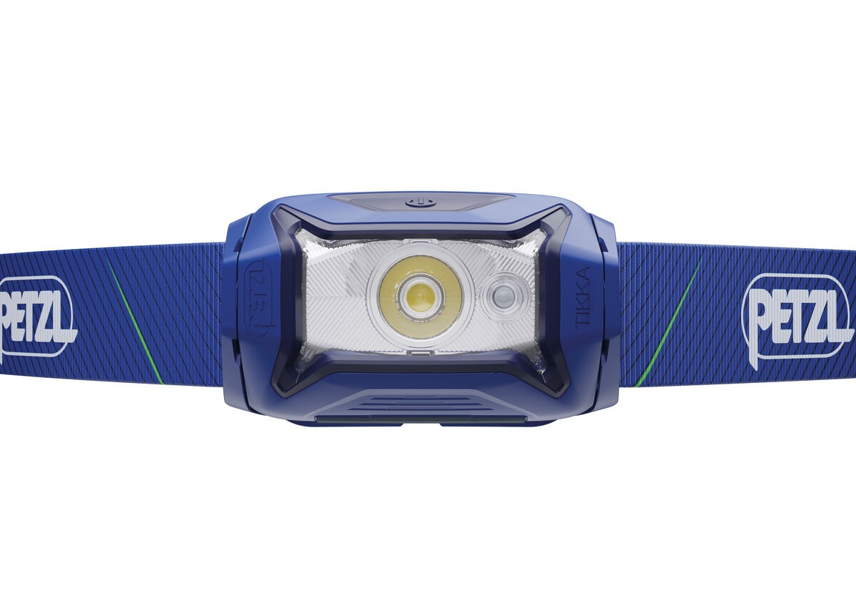 Petzl TIKKA CORE zblízka spredu — v priehľadnej optike jedna veľká biela LED so žltým fosforom a vedľa nej menšia červená LED, hore ovládacie tlačidlo
