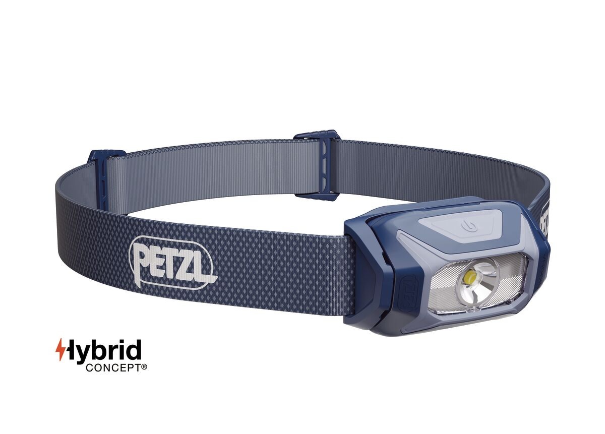 Petzl TIKKINA 2025 v modrej farbe — tmavomodré telo so svetlosivým rámom optiky a modrosivý pásik s kosoštvorcovým vzorom