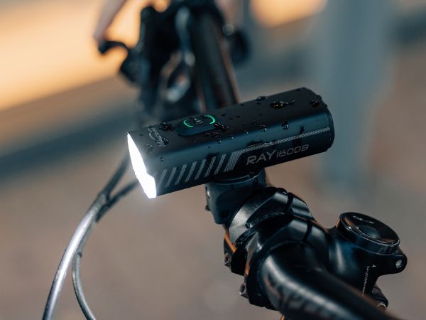 Cyklosvetlo Magicshine RAY 1600B nasadené v držiaku na riadidlách bicykla so svietiacim predným lúčom