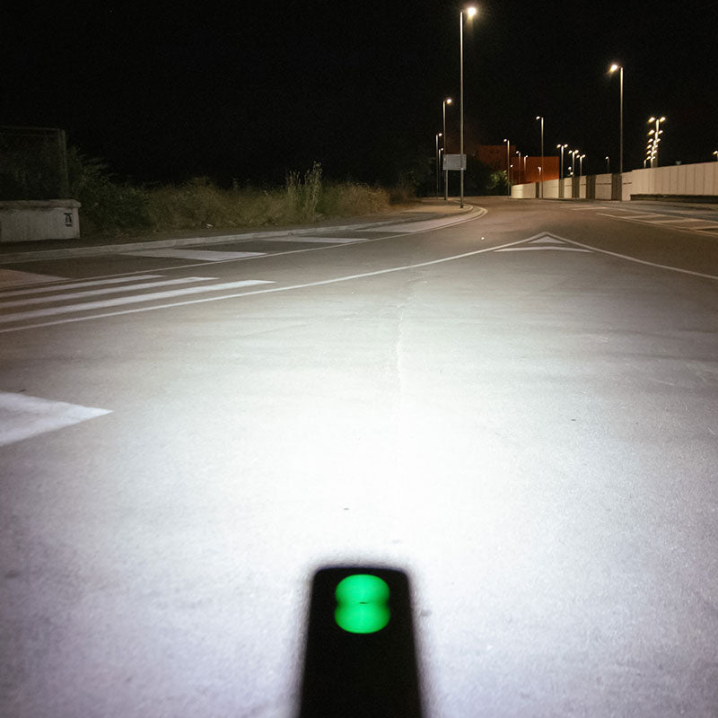Pohľad z riadidiel na nočnú cestu zaliatu širokým lúčom cyklosvetla Magicshine RAY 2600B s 2600 lúmenmi