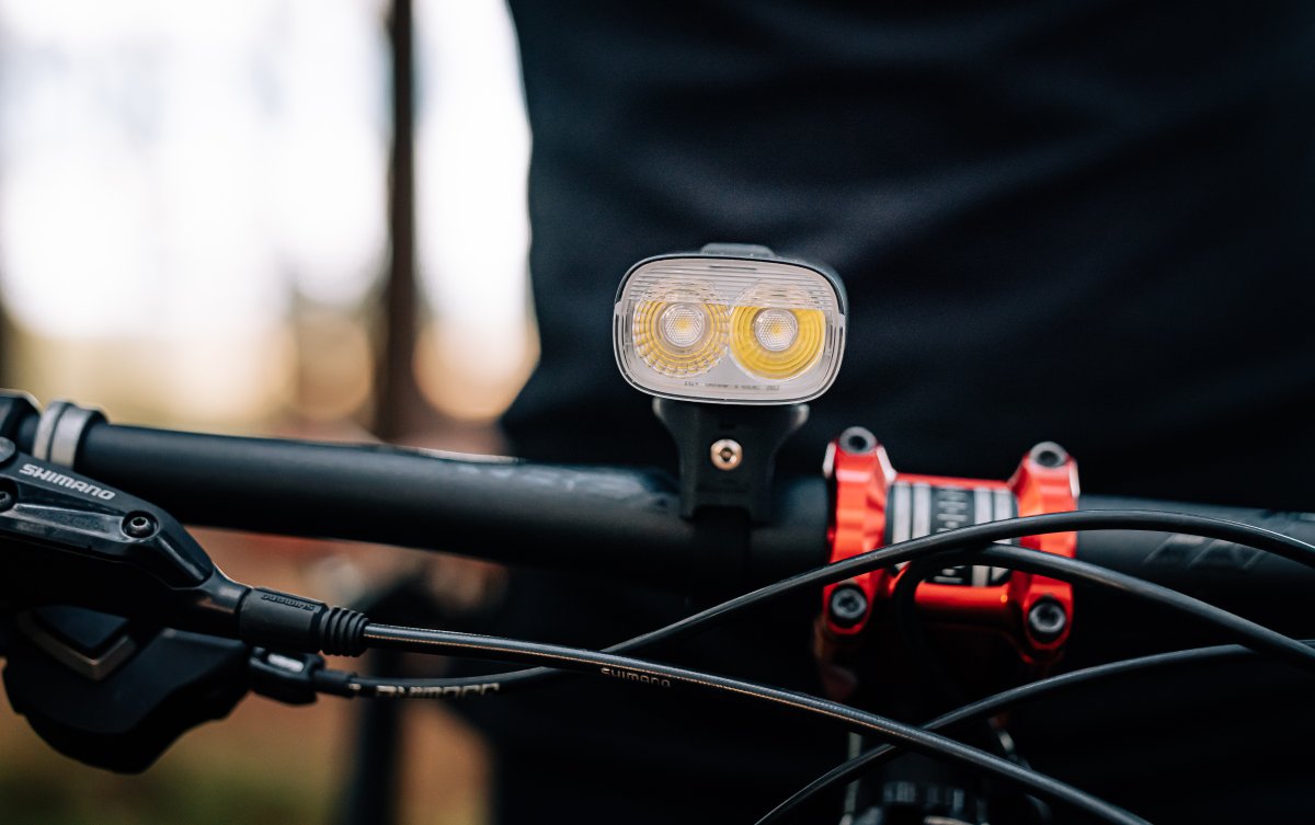 Magicshine RN 3000 nasadené na riadidlách horského bicykla &ndash; predné cyklosvetlo s dvoma LED v lesnom teréne