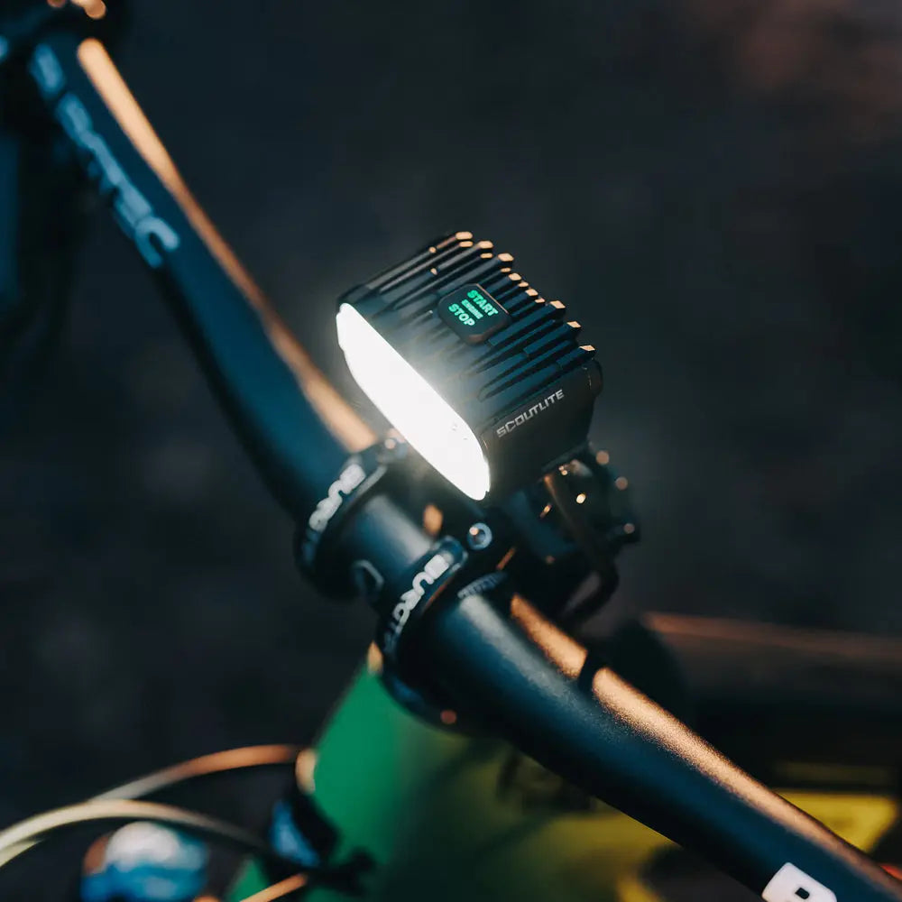 Rozsvietená Scoutlite MEGLE 6000 na riadidlách horského bicykla v noci