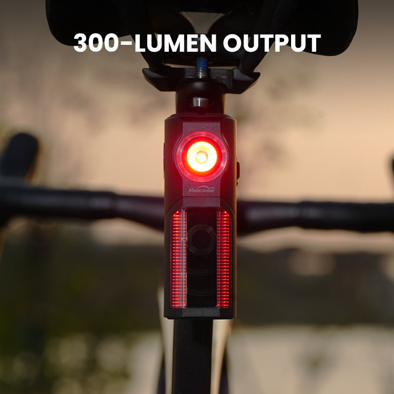 Fotografia výrobcu Magicshine: rozsvietené zadné svetlo SEEMEE R300 na sedlovke bicykla za súmraku, okrúhla LED aj bočné svetelné pásy