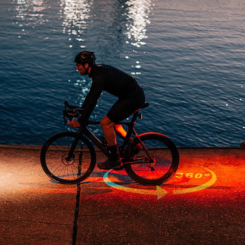 Zadné svetlo Magicshine SEEMEE 300 kreslí na asfalt červený kruh 360 stupňov okolo bicykla pri nočnej jazde