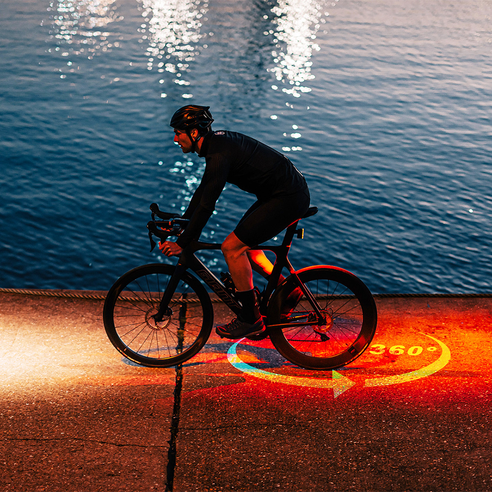 Zadné svetlo Magicshine SEEMEE 400 ANT+ kreslí na asfalt červený kruh 360 stupňov okolo bicykla pri nočnej jazde