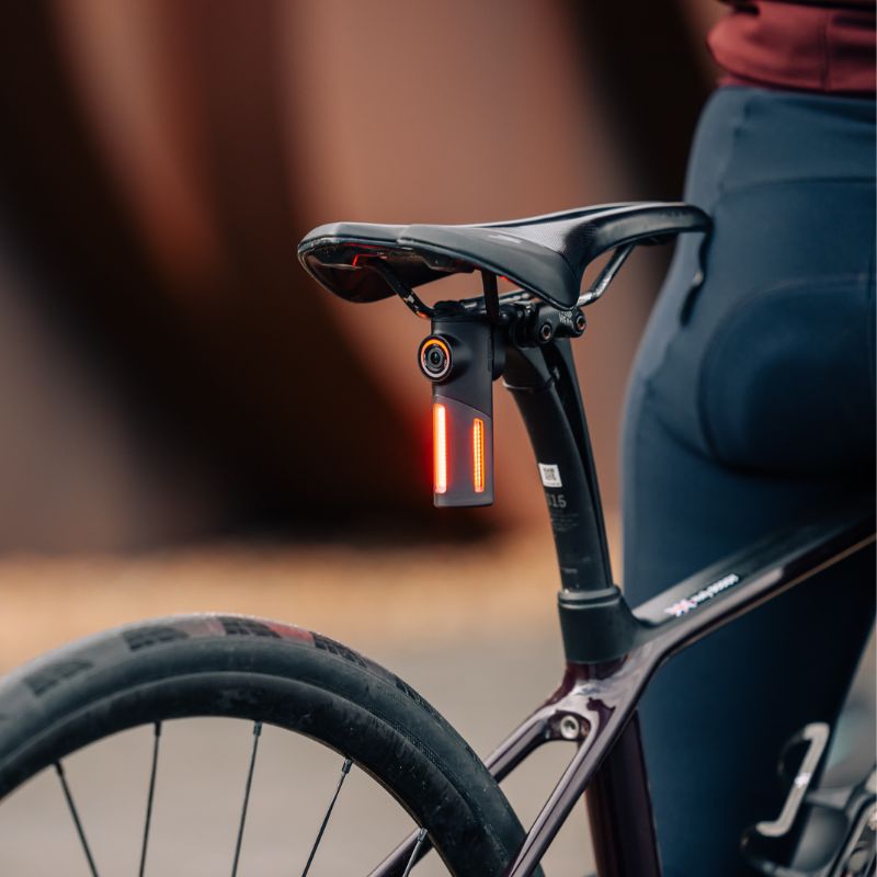 Cestný bicykel s cyklistom, zadné svetlo Magicshine SEEMEE DV s kamerou upnuté na sedlovke pod sedlom