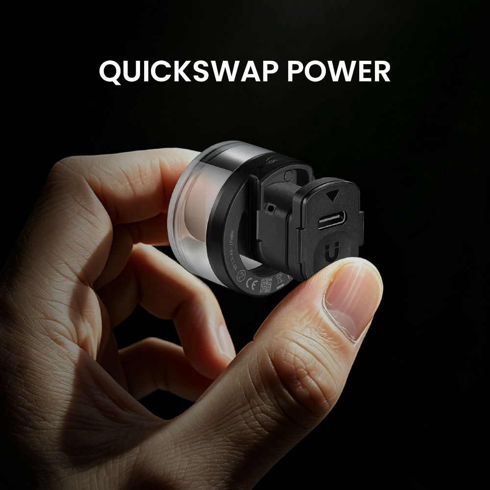 Ruka drží zadné svetlo Magicshine VIVEE 50 HALO s vysunutou akumulátorovou kapsulou QuickSwap a portom USB-C