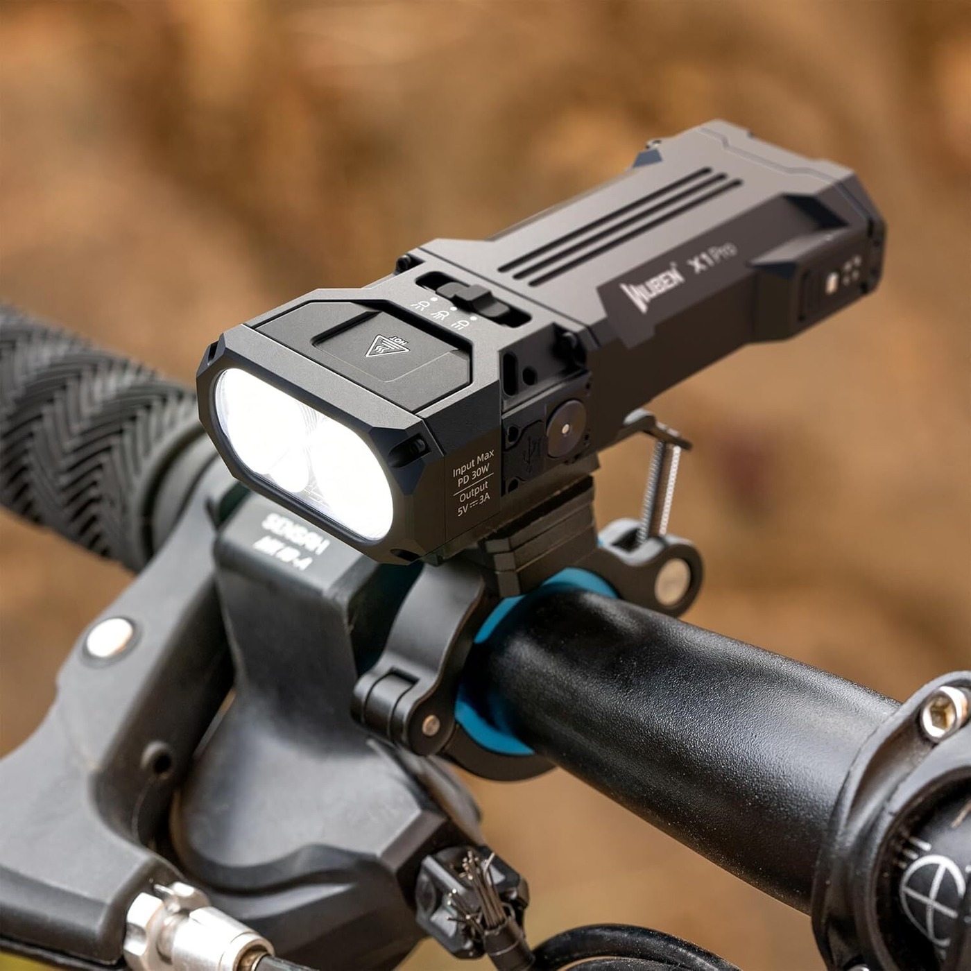 Wuben AT2XP na riadidlách bicykla s rozsvietenou baterkou X1 Pro, pohľad na objímku pri predstavci