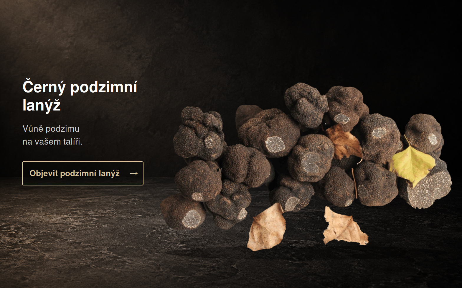 Černé podzimní lanýže s listy na černém podkladu