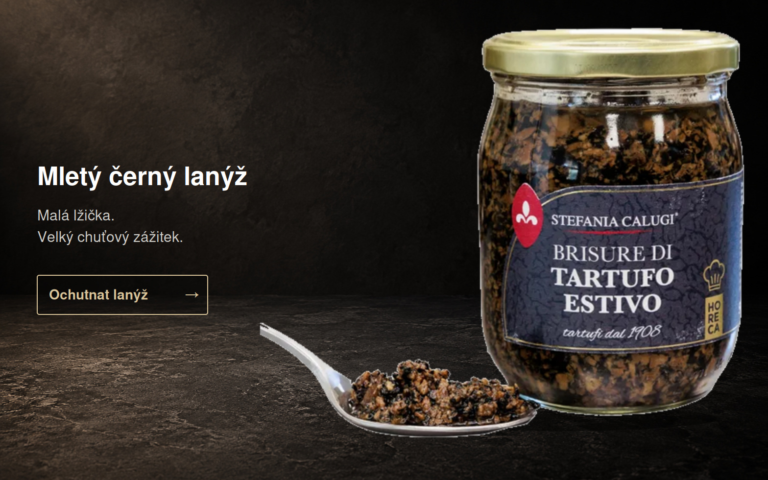 Mletý černý lanýž – celá sklenička se lžičkou na tmavém podkladu
