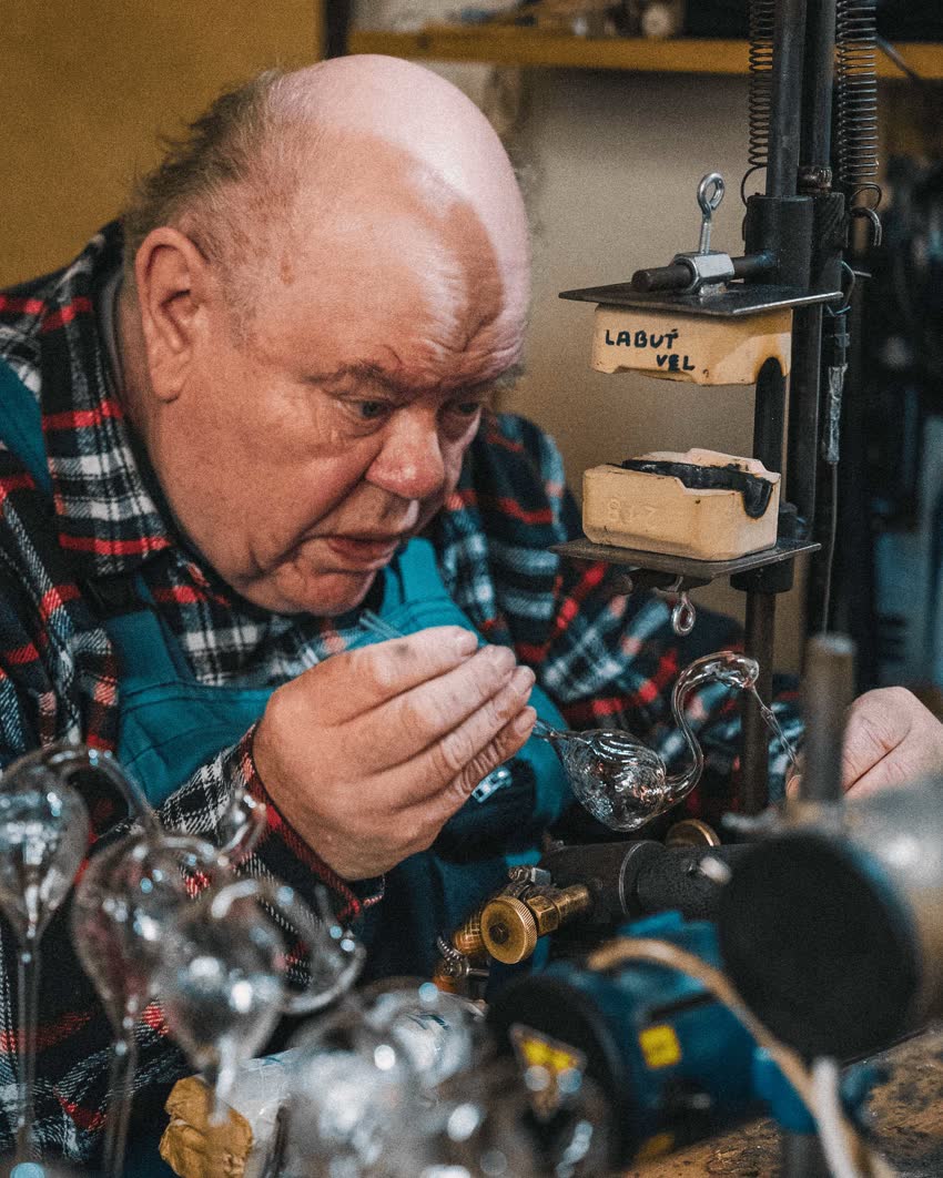 Sklář při ručním foukání skleněné figurky v dílně v Lánově