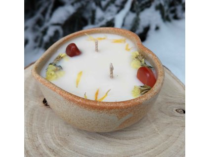 Dekorační svíčka s minerály a jemnými kvítky v misce z kameniny ve tvaru srdce.