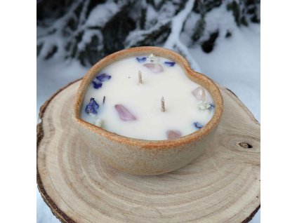 Dekorační svíčka s minerály a jemnými kvítky v misce z kameniny ve tvaru srdce.